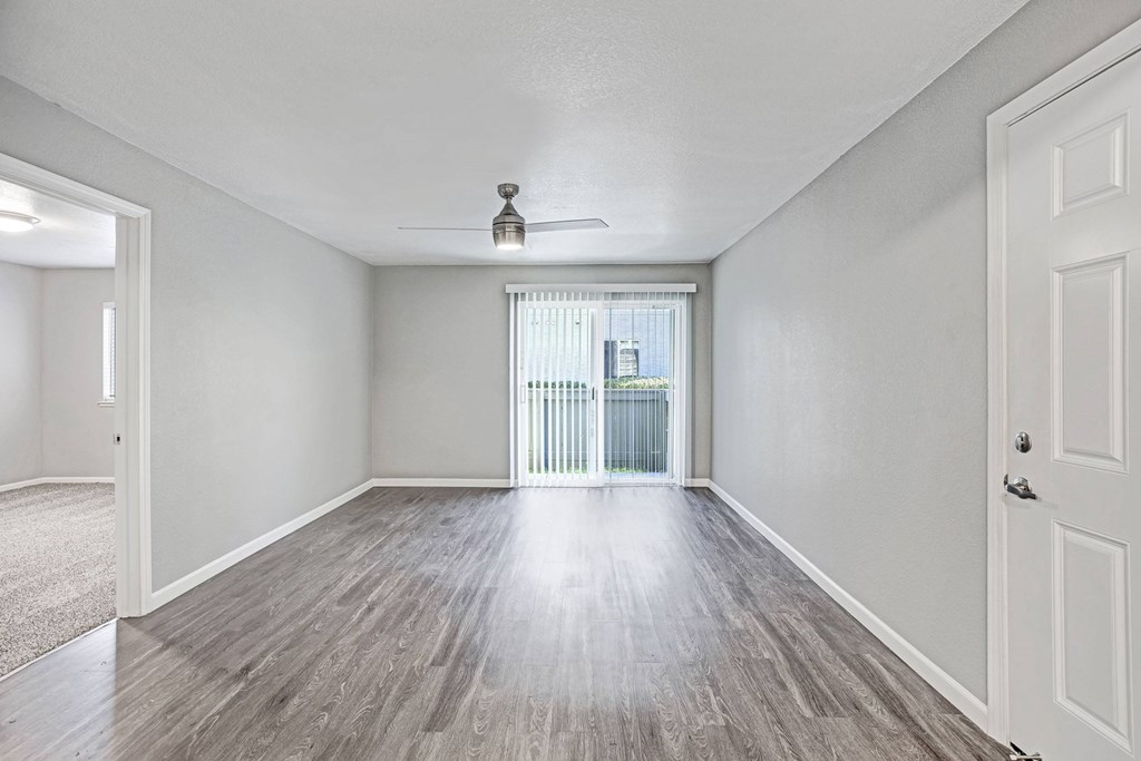 A room with a ceiling fan and sliding glass doors at The Henley Apartments, California