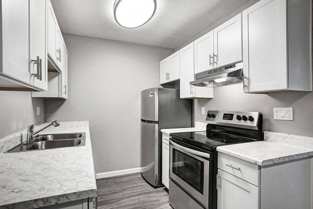 A kitchen with a stove, oven, and sink at The Henley Apartments, Suisun City, California