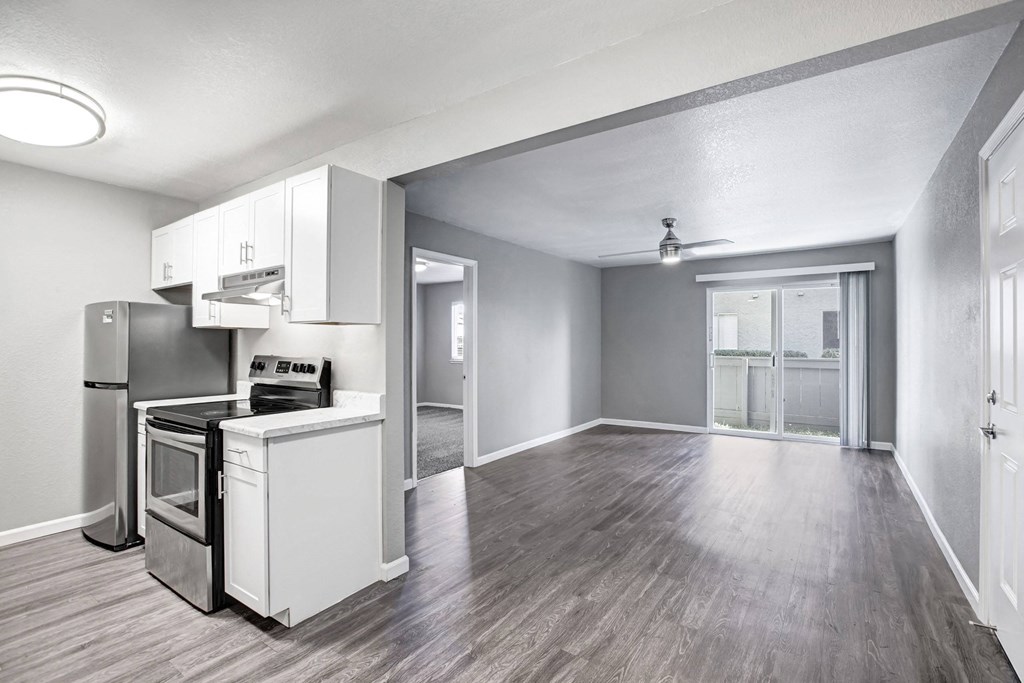 A kitchen with a refrigerator, oven, and sink at The Henley Apartments, Suisun City, CA