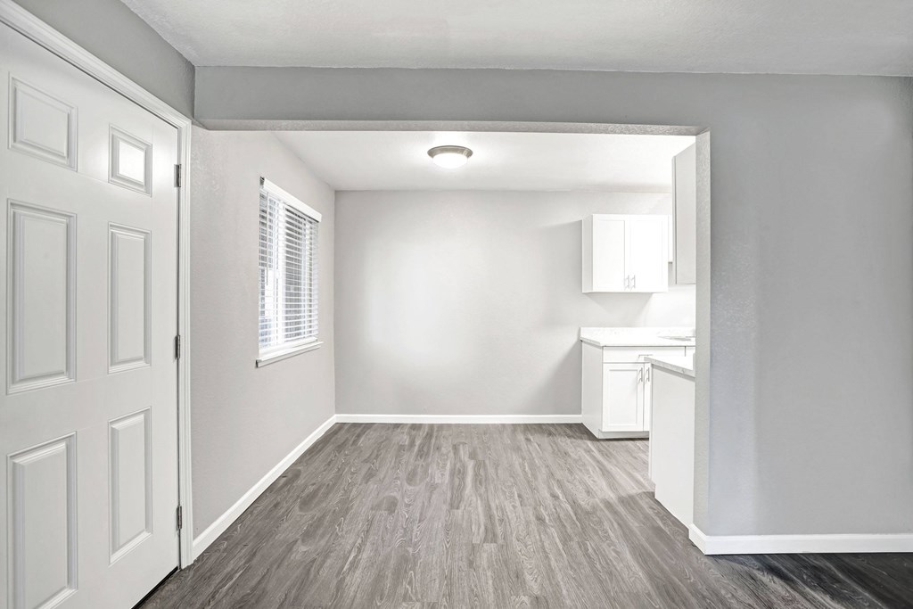 A white room with a wooden floor and a door at The Henley Apartments, Suisun City, 94585