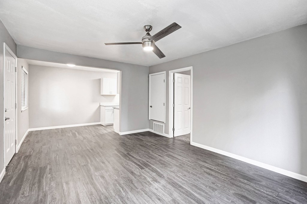 A room with a ceiling fan and light fixture, and a door to the right at The Henley Apartments, Suisun City, 94585