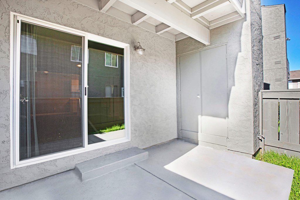 A patio area with a white door and a window at The Henley Apartments, Suisun City