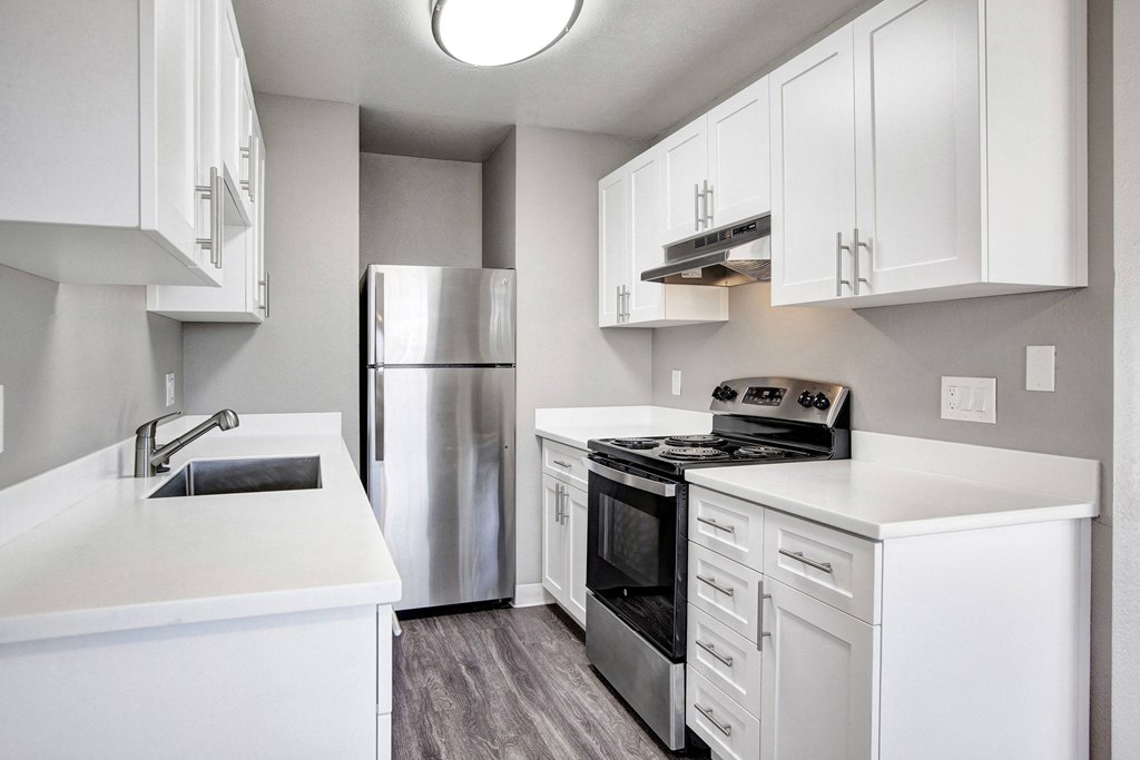 A modern kitchen with white cabinets and stainless steel appliances at The Henley Apartments, Suisun City, CA, 94585