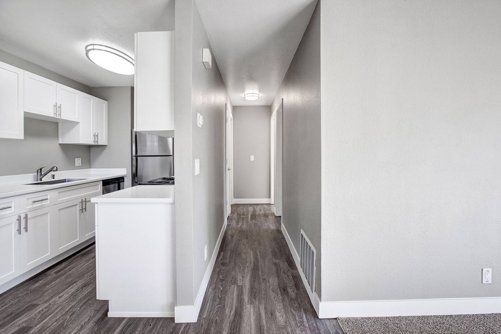A kitchen with white cabinets and a white sink at The Henley Apartments, California, 94585
