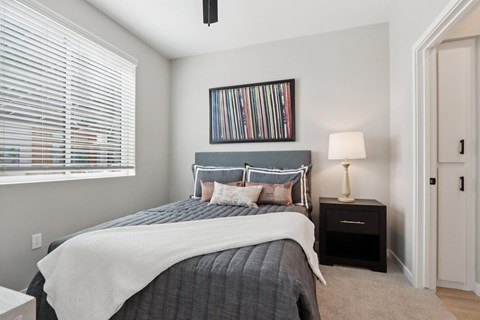 A bedroom with a bed, nightstand, and a picture frame on the wall at Ironwood Ranch Apartments,Maricopa,AZ,85138