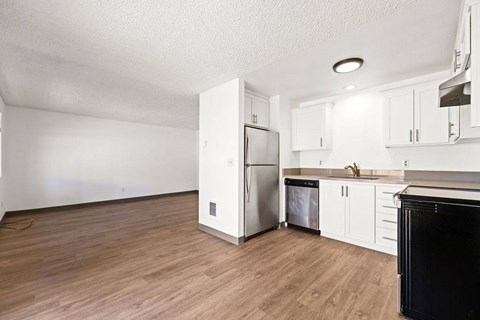 A kitchen with white cabinets and a black oven.