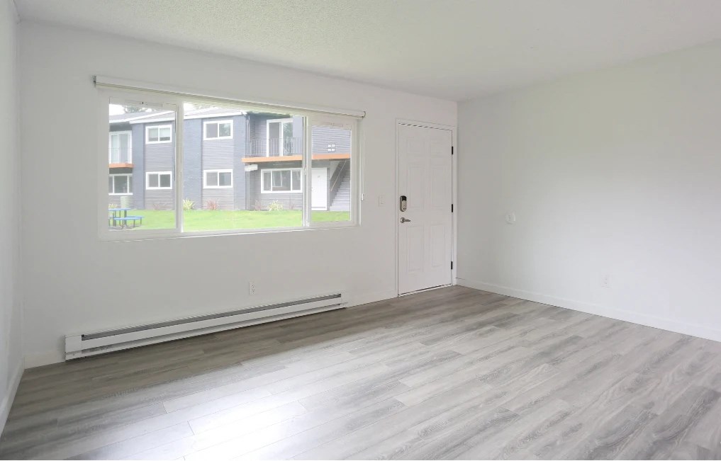 A room with a large window overlooking apartment buildings.at Tigardville Apartments, Oregon