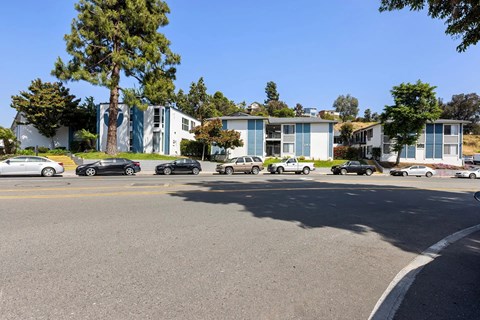 A parking lot with cars and a building in the background.