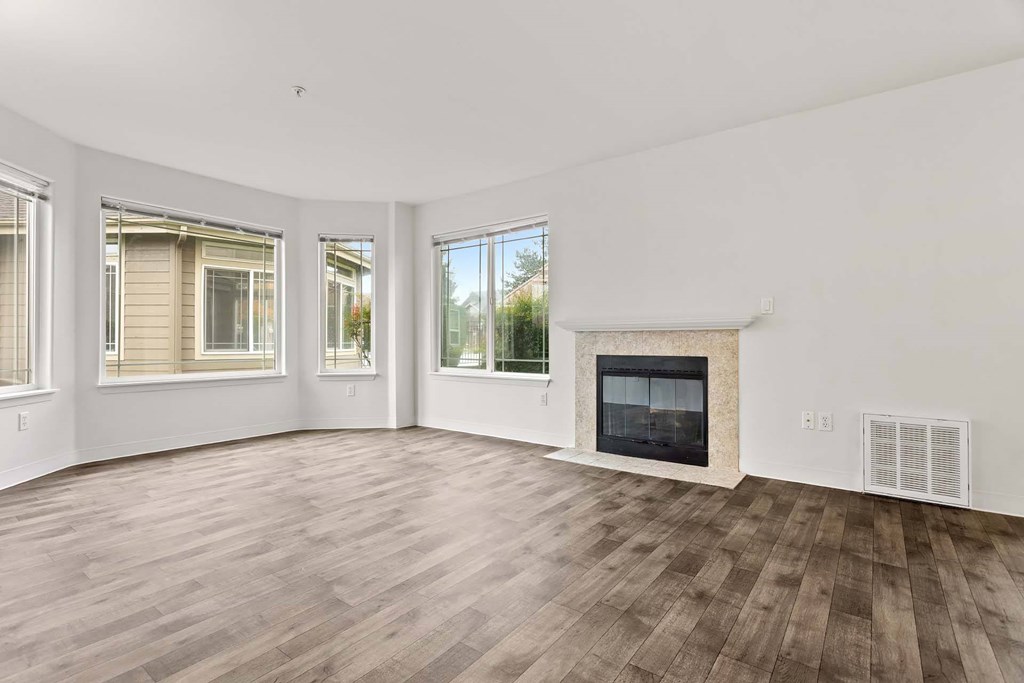 A living room with a fireplace and wood flooring.at Maple Ridge, Vancouver Washington