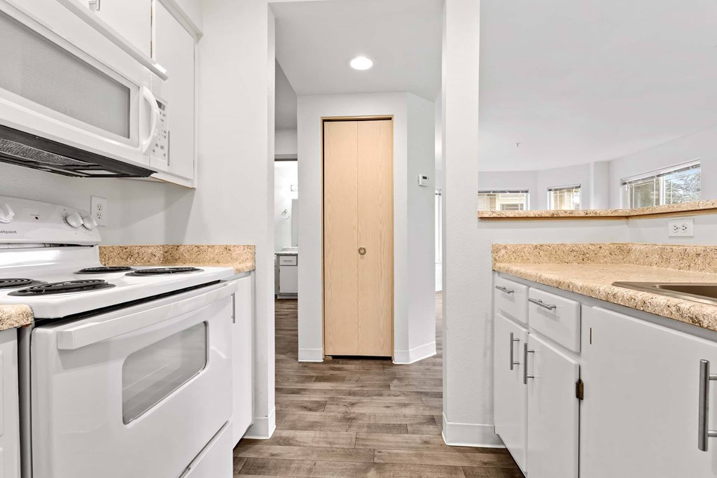 A kitchen with white appliances and a wooden door.at Maple Ridge, Washington