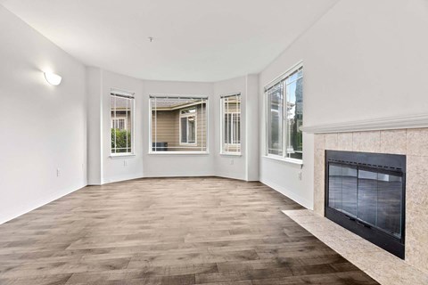 A living room with a fireplace and a large window.