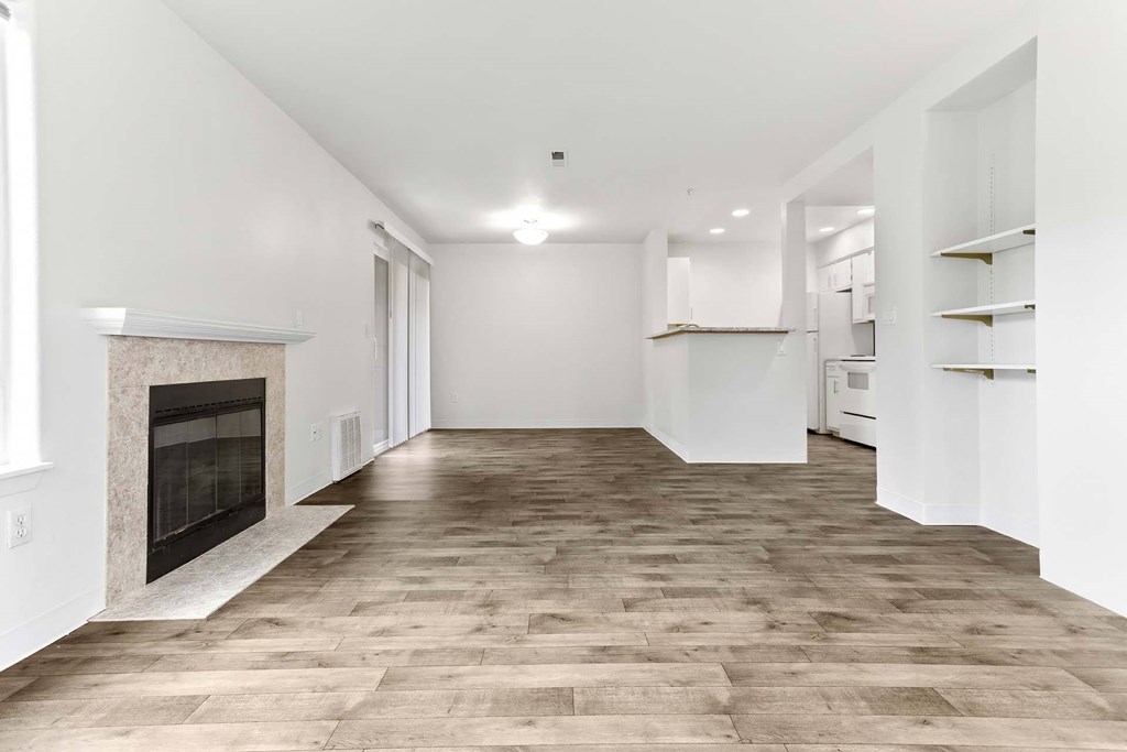 A spacious room with a fireplace and wooden flooring.at Maple Ridge, Vancouver Washington