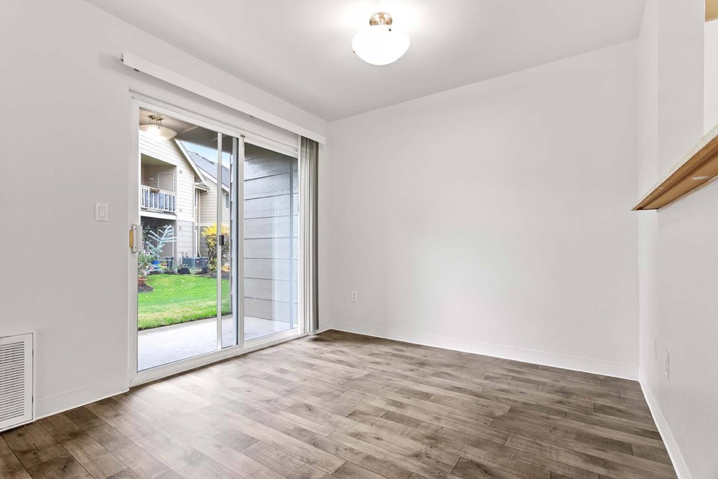A room with a sliding glass door leading to a backyard.at Maple Ridge, Vancouver Washington