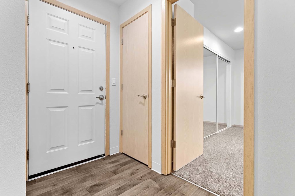 A hallway with a white door on the left and a wooden door on the right.at Maple Ridge, Vancouver, WA 98664
