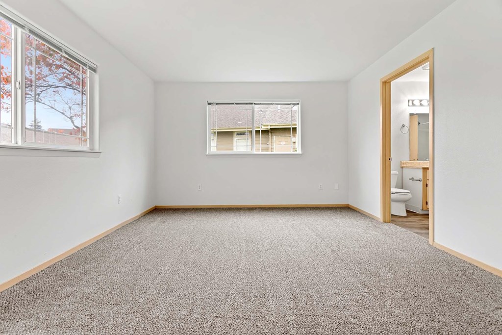 A room with a carpeted floor and a window.at Maple Ridge, Vancouver