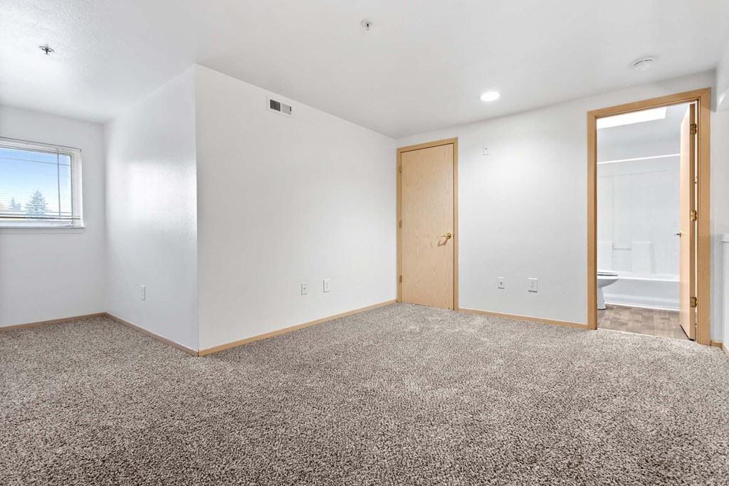 A room with a carpeted floor and a window.at Maple Ridge, Vancouver Washington