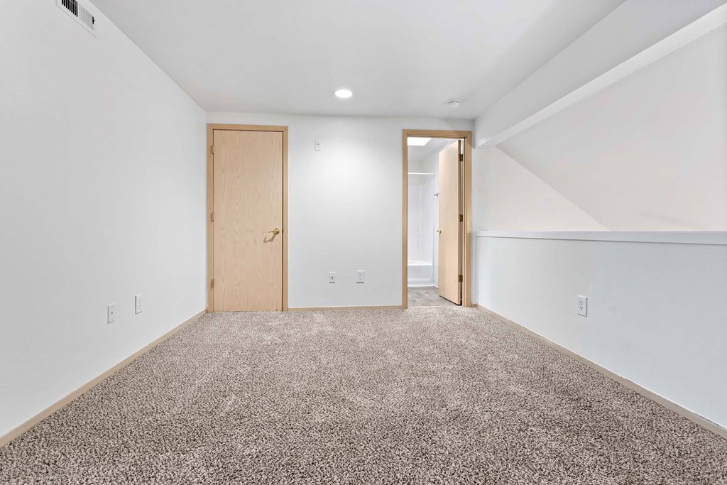 A room with a carpeted floor and two doors.at Maple Ridge, Vancouver