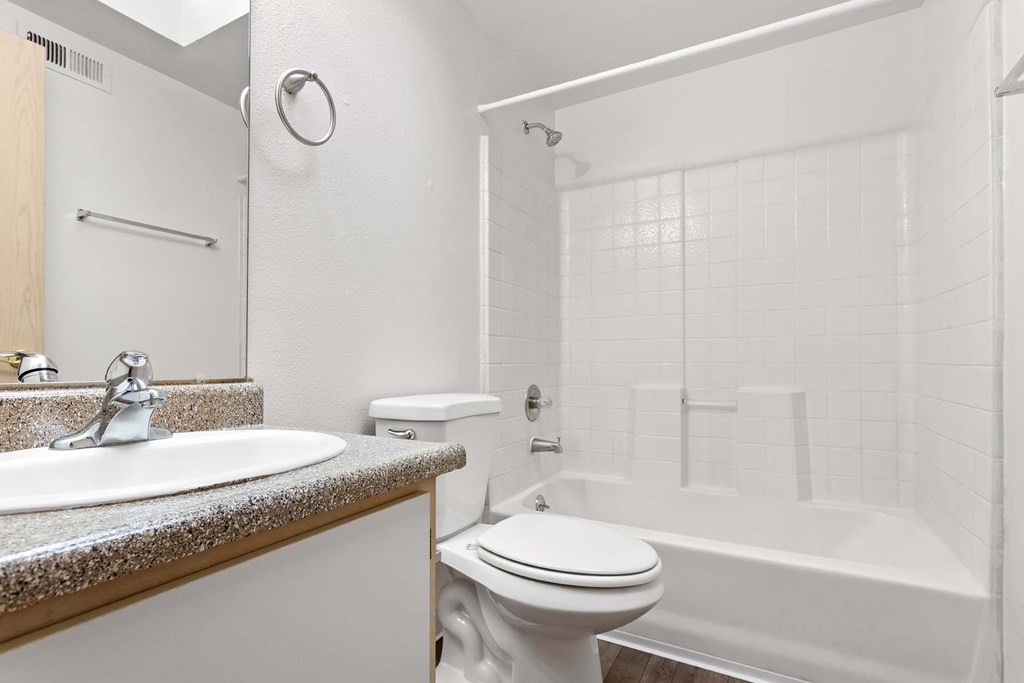 A white bathroom with a toilet, sink, and bathtub.at Maple Ridge, Vancouver, WA