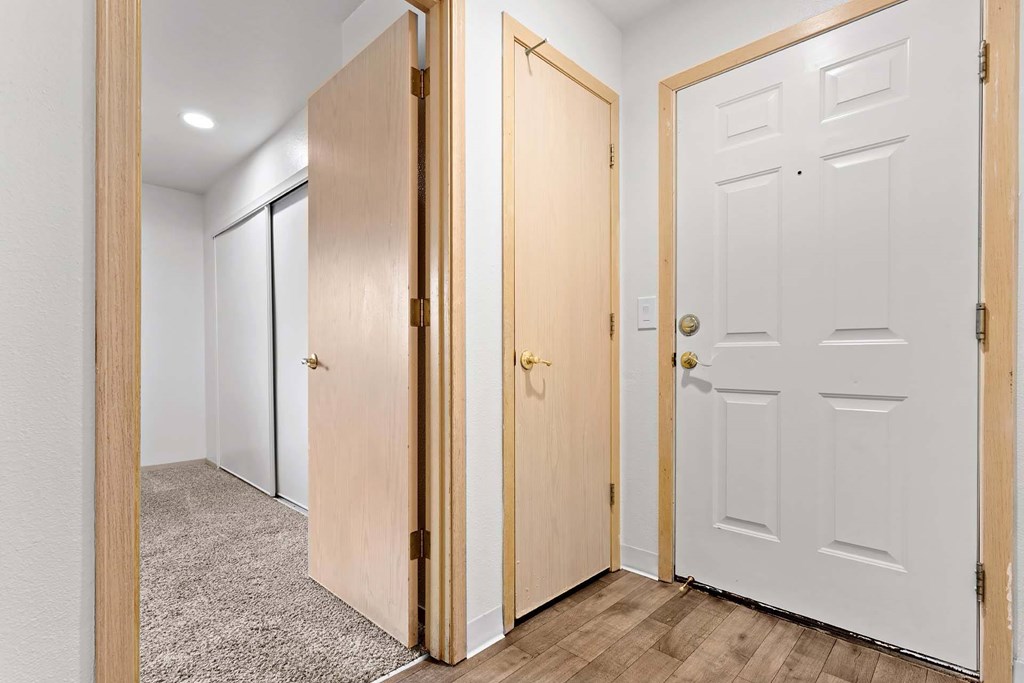 A hallway with two doors on the right and a white door on the left.at Maple Ridge, Washington