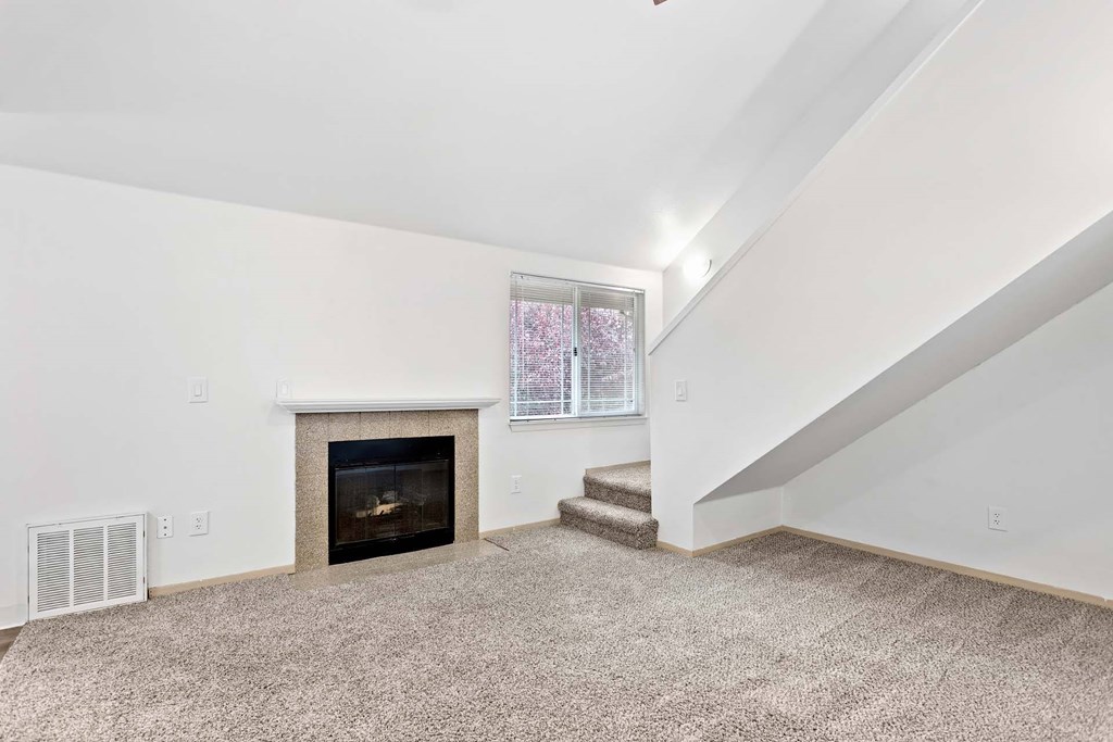 A living room with a fireplace and a staircase.at Maple Ridge, Vancouver