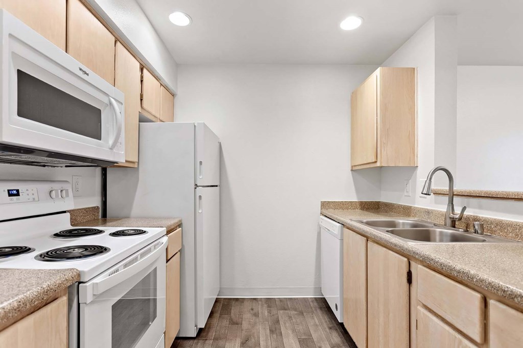 A kitchen with white appliances and wooden cabinets.at Maple Ridge, Vancouver, WA 98664