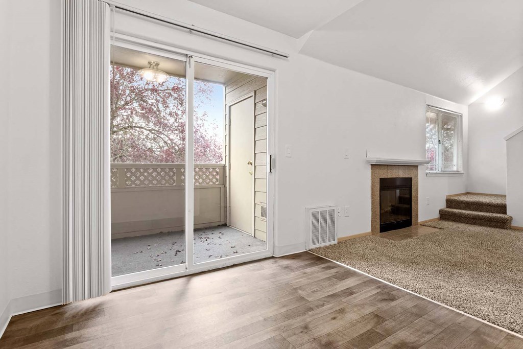 A room with a fireplace and a rug on the floor.at Maple Ridge, Vancouver, WA