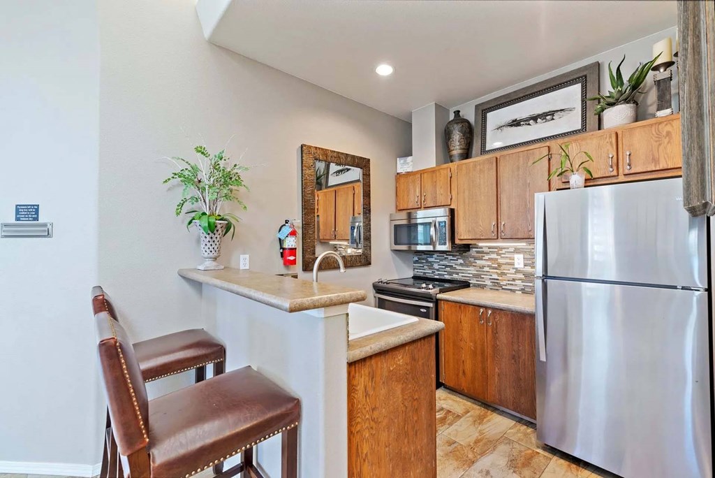 A kitchen with a refrigerator, stove, and a chair.at Maple Ridge, Vancouver, 98664