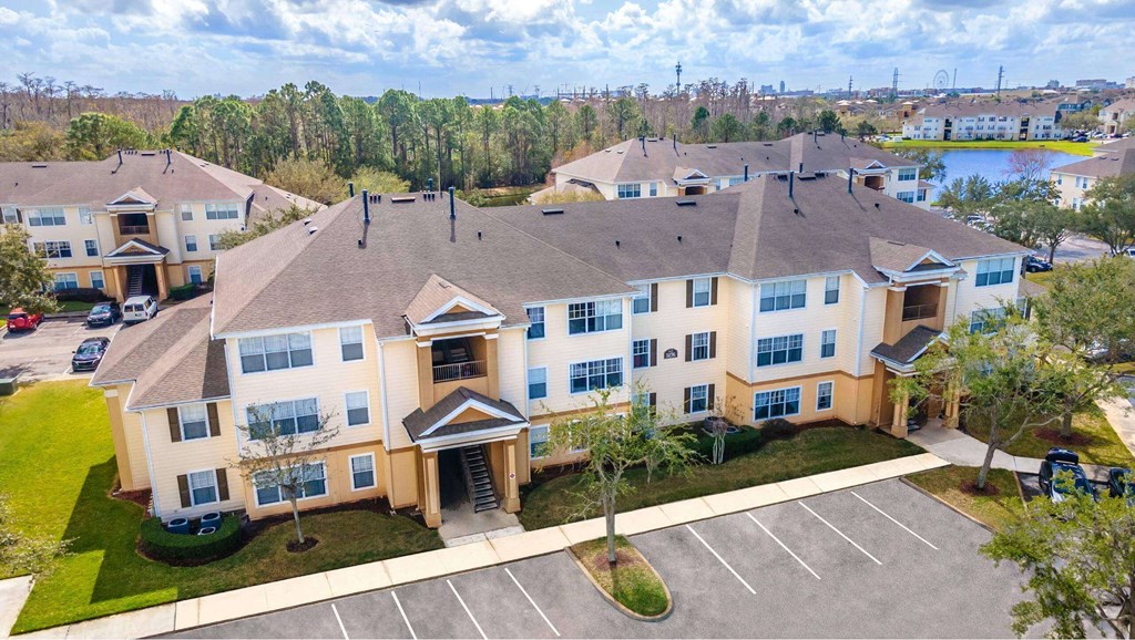 A large apartment complex with a parking lot in front at The Villages on Millenia Apartments, Florida, 32839