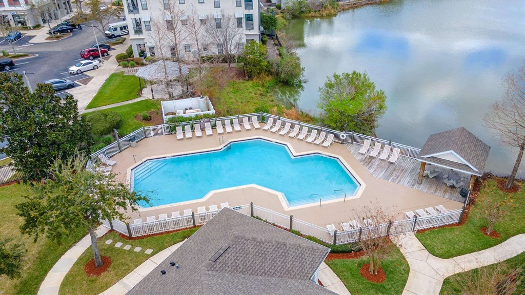 A large swimming pool surrounded by a white fence at The Villages on Millenia Apartments, Florida