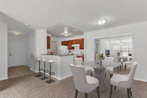 A modern kitchen with a dining table set up with chairs.
