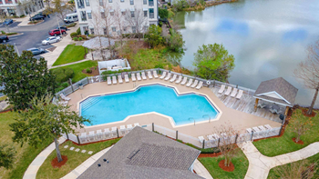 A large swimming pool surrounded by a white fence at The Villages on Millenia Apartments, Orlando, FL