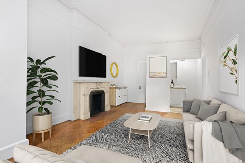 A living room with a fireplace and a television on the wall.