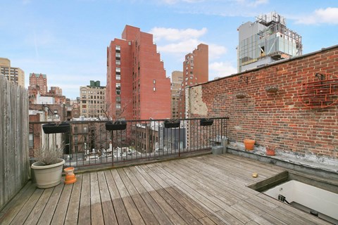 A wooden deck with a red building in the background.
