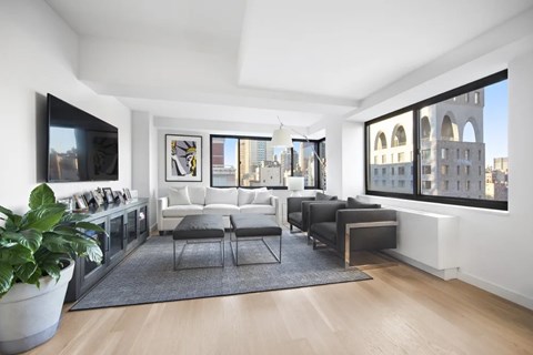 A living room with a grey sofa and a large window.