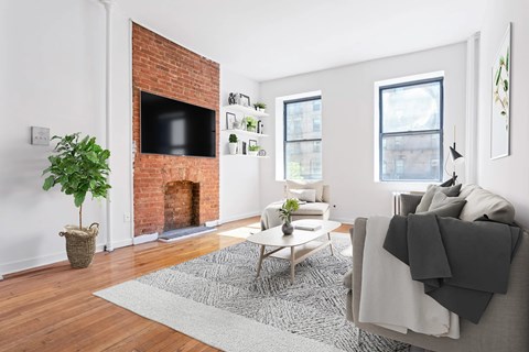 A living room with a fireplace and a tv on the wall.