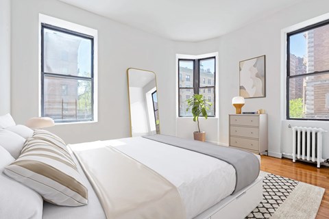A bedroom with a large bed, a dresser, and a mirror.