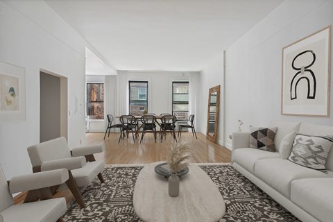 A living room with a white couch, a coffee table, and a painting on the wall.