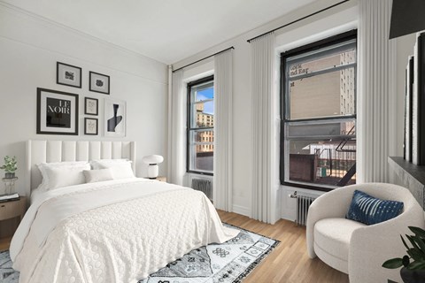 A bedroom with a large bed and a window overlooking a city.