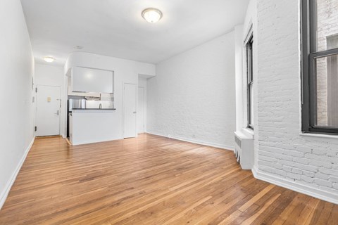 A room with wooden flooring and white walls.