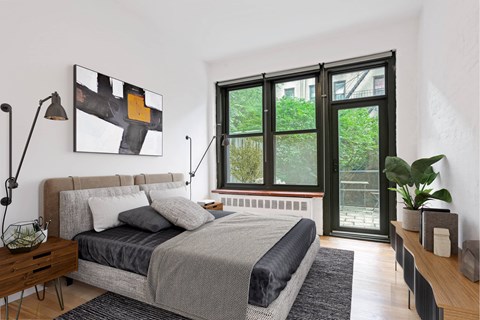 A bedroom with a bed, nightstand, and a painting on the wall.