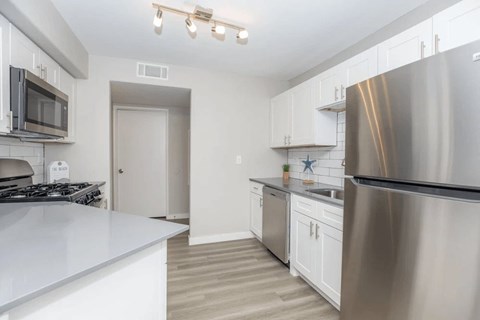 A modern kitchen with stainless steel appliances and white cabinetry.