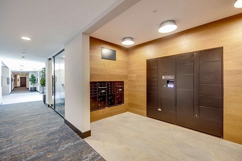 a photo of the lobby of a building with a lockers and a door