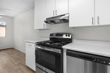 Kitchen with white cabinets and stove l Palmilla Apartments - Photo Gallery 2