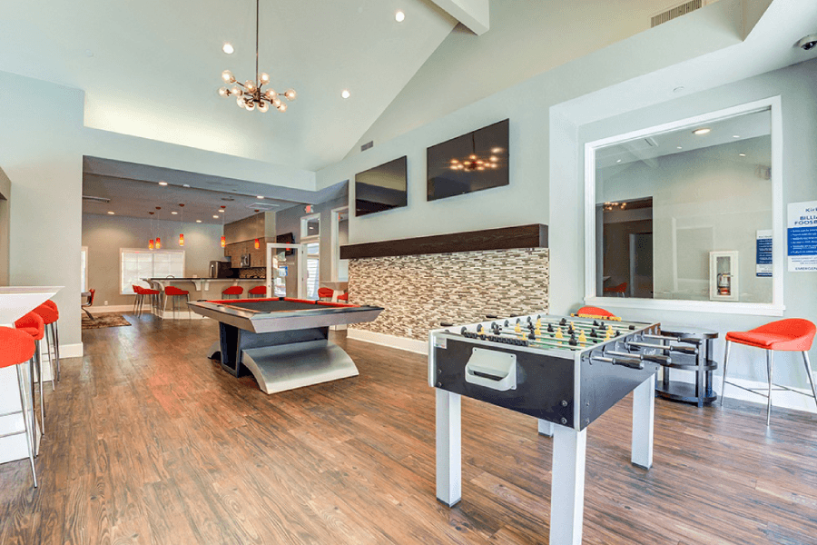 A room with a foosball table and a shaggy rug at Kirker Creek Apartments, Pittsburg