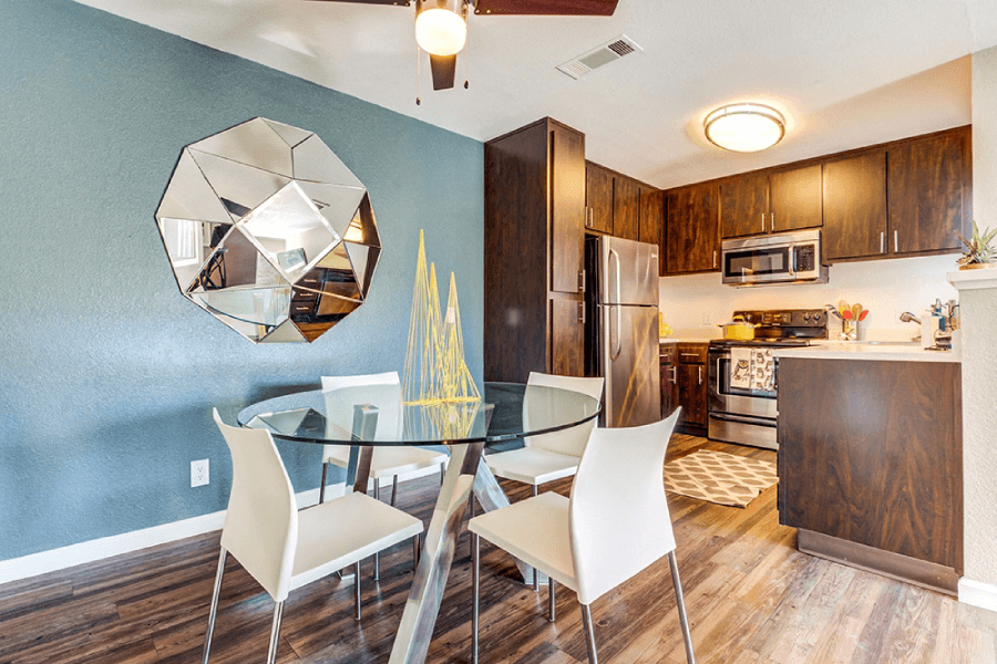 A modern kitchen with a glass dining table and chairs at Kirker Creek Apartments, Pittsburg, CA