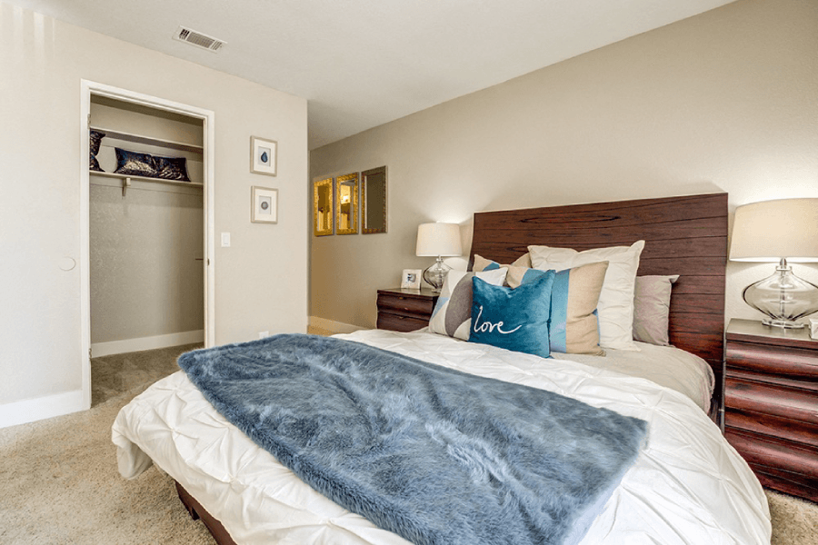 A bedroom with a bed covered in a blue blanket.