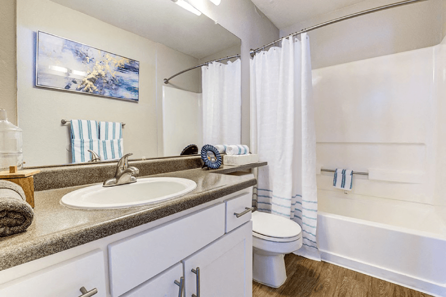 A bathroom with a white tub, sink, and toilet at Kirker Creek Apartments, Pittsburg 94565