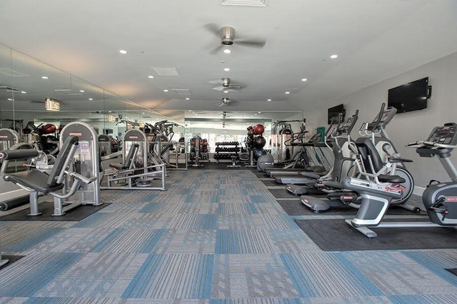 A gym with a variety of exercise equipment at Kirker Creek Apartments, California