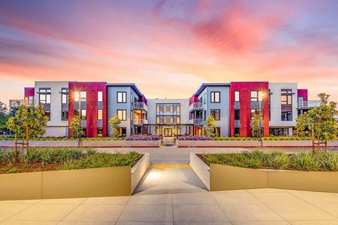 a rendering of an apartment complex with a sunset in the background