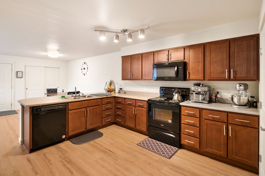 a kitchen with wooden cabinets and a black stove and microwave
